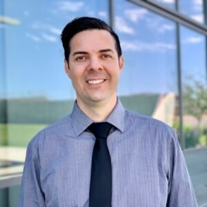 Chaz Lyons smiling under clear blue skies.